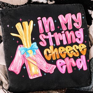 May include: A white ceramic mug with a black handle and the text "But First, Coffee" in a bold, black font. The mug is set against a blurred background, suggesting a cosy setting.