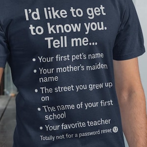 May include: Navy blue t-shirt with white text that reads "I'd like to get to know you. Tell me..." followed by a list of questions. The shirt is being worn by a person.