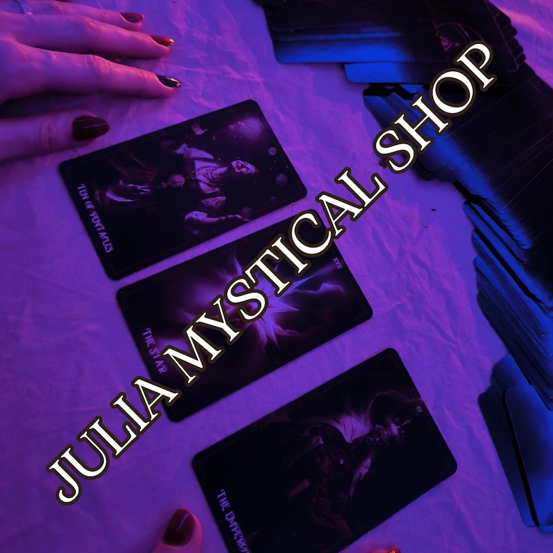 May include: Three rectangular tarot cards laid out on a surface under purple lighting. The cards are labeled Ten of Pentacles, The Star, and The Emperor. A stack of additional cards is visible to the right, and the text JULIA MYSTICAL SHOP is present.