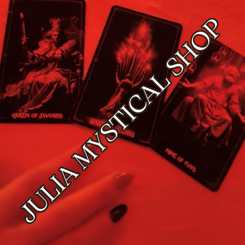 May include: Three black tarot cards with red-tinted imagery, including the Queen of Swords, Seven of Wands, and Nine of Cups. The cards feature detailed illustrations and text labels. The text JULIA MYSTICAL SHOP is overlaid across the cards.