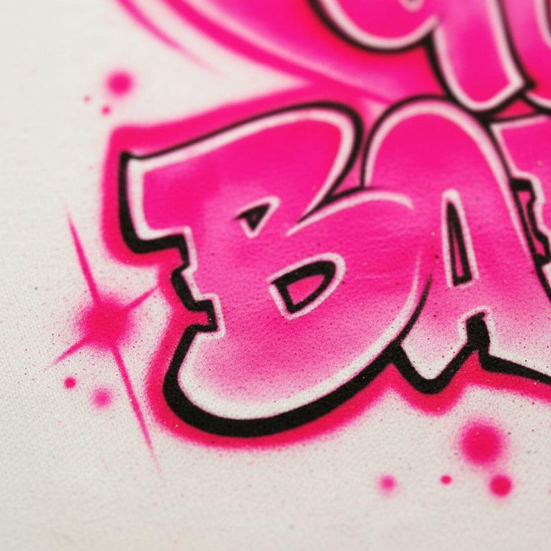 A close-up of a pink and black graffiti-style text on a white background.