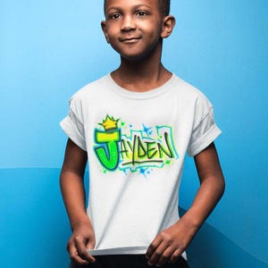 a young boy standing in front of a blue wall