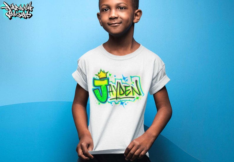 a young boy standing in front of a blue wall