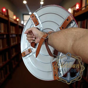 Captain America shield replica, metal wall decor with red/white/blue and star; engraved outer ring, personalized cosplay gift.