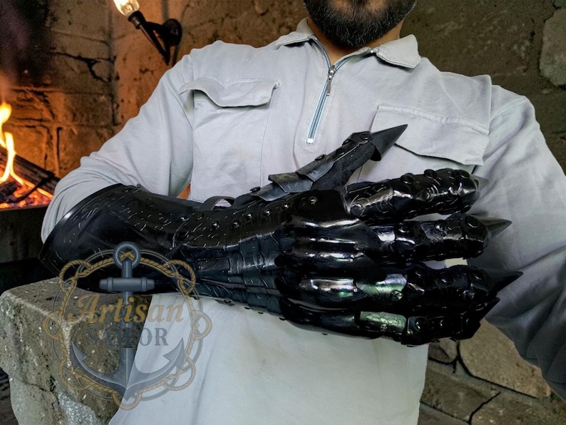 Pu&ograve; includere: Guanto in metallo nero con dita articolate e artigli affilati. Il guanto &egrave; indossato sul braccio e presenta dettagli intricati e una finitura lucida. Il design ricorda un artiglio di drago, perfetto per cosplay o appassionati di fantasy.