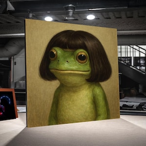 May include: A whimsical artwork depicts a green frog with large, expressive eyes and a brown bob haircut. The frog is centered on a canvas with a tan background. The artwork is displayed in a gallery setting.