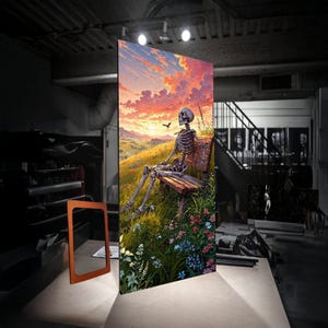 Puede incluir: Una gran impresión rectangular en lienzo representa un esqueleto sentado en un banco de madera, con vistas a un paisaje de puesta de sol. La obra de arte presenta colores vibrantes, incluyendo naranja, amarillo y azul, con un pájaro en vuelo. La escena está ambientada en un campo de flores silvestres.