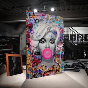 May include: A large, colorful pop art canvas featuring a grayscale portrait of a woman blowing a bubblegum bubble. The artwork is embellished with graffiti-style paint splatters and the word "Beautiful".
