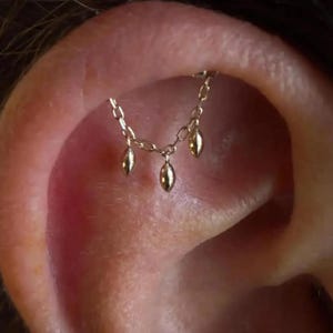 Pendiente de cartílago con cadena oculta de hélice chapada en oro de 16 g, parte trasera plana, piercing celestial, labio de titanio, piercing para trago con concha.