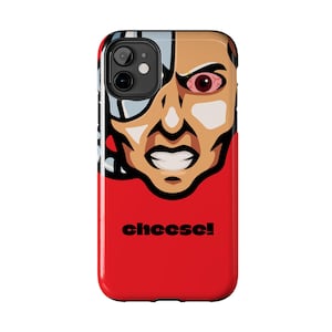 Könnte beinhalten: Eine rote iPhone-Hülle mit einer Comic-Illustration eines Cyborg-Charakters mit wütendem Gesichtsausdruck. Die Figur hat ein rotes Auge und das Wort "cheese!" ist in Schwarz gedruckt.