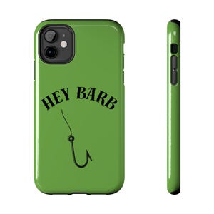 Può includere: Una custodia per telefono verde con la scritta nera "HEY BARB" ad arco sopra un disegno di amo da pesca nero. La custodia ha una finitura lucida e un ritaglio nero per l'obiettivo della fotocamera.