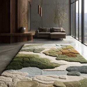 May include: A large, textured area rug with a landscape design in shades of green, beige, and blue. The rug's design resembles rolling hills or a natural terrain, adding a touch of nature to the room. The rug is placed in a modern living space.