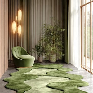 May include: A modern living room featuring a green, organic-shaped rug. A green armchair sits near the rug, with plants and curtains in the background. The room has a neutral color palette with natural light.