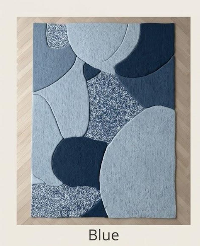 May include: A rectangular blue rug with an abstract design. The rug features various shades of blue, including light, medium, and dark tones, arranged in organic shapes. The word "Blue" is printed at the bottom of the image.