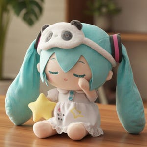 May include: A plush doll with light blue hair and a panda eye mask. The doll wears a white dress and holds a yellow star. The doll has closed eyes and is sitting on a wooden surface.