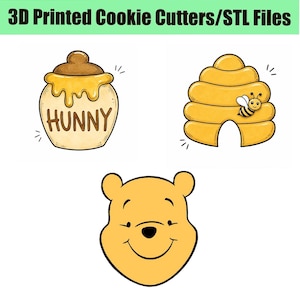 May include: Three 3D printed cookie cutters or STL files featuring a honey pot labeled HUNNY, a yellow beehive with a small bee, and the face of a yellow bear. The text 3D Printed Cookie Cutters/STL Files is displayed at the top of the image.