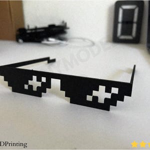 3D printable Thug Life Glasses designed as pixel meme style deal with it shades. A funny costume prop and desk accessory perfect for photos, parties, and cosplay. Lightweight and easy to wear, Blender optimized and fully compatible with BambuLab printers.