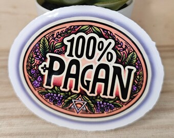 May include: An oval sticker with the text "100% PAGAN" in black, red, and white, surrounded by a floral design in pink, purple, and green. A small green plant in a white pot is in the background.