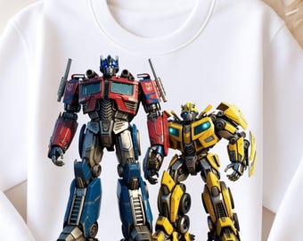 May include: White crewneck sweatshirt featuring a graphic of Optimus Prime and Bumblebee from Transformers. Optimus Prime is red, blue, and silver. Bumblebee is yellow and black. The word "TRANSFORMERS" is printed in black at the bottom.