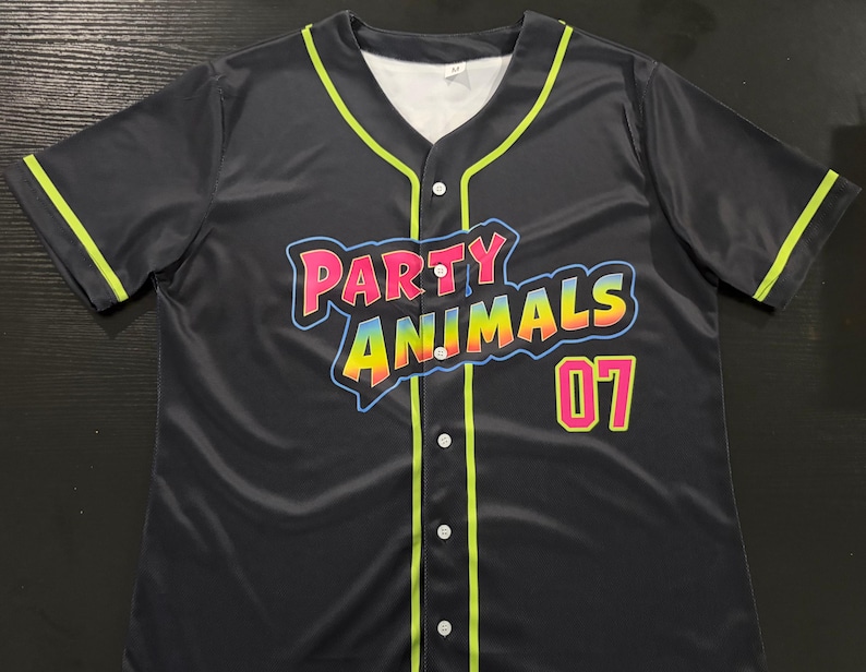 May include: A black short-sleeve button-down baseball jersey featuring neon green piping along the collar, placket, and sleeves. The front displays the text "PARTY ANIMALS" in a colorful gradient font with a blue outline and the number "07" in pink.