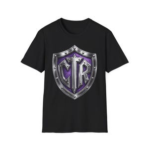 May include: Black t-shirt featuring a shield design with the letters "CTR" in silver. The shield has a purple background and a silver border with rivets. The t-shirt is made of a soft material and has a crew neck.