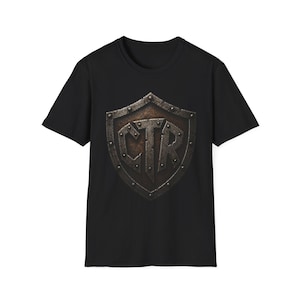 May include: Black t-shirt featuring a distressed shield design with the letters "CTR" in a bold, metallic font. The shield has a textured, aged appearance, suggesting a vintage or medieval theme. The shirt is a classic crew neck style.