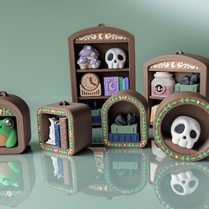 May include: A collection of brown miniature decorative shelves and arched frames, each containing a unique object. Items include a frog, books, a black cat, a skull, a clock, and a mushroom. The shelves are decorated with floral and leaf patterns.