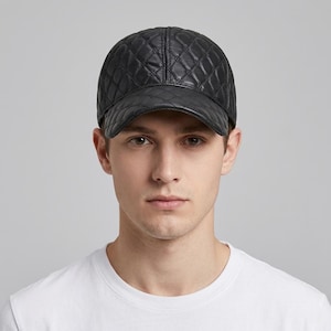 Peut inclure: Casquette de baseball noire avec un motif matelassé. La casquette a une visière incurvée et une couronne structurée. Fabriquée dans un matériau semblable au cuir, elle est idéale pour un usage décontracté.