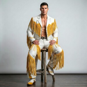 Puede incluir: Una chaqueta de cuero blanco y pantalones de cuero blanco a juego, ambos con largos flecos de color amarillo mostaza en el pecho, los hombros y las piernas. El conjunto incluye una hebilla de cintur&oacute;n plateada y botas de cuero blanco con detalles amarillos.
