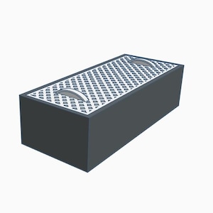 May include: A rectangular, dark gray box with a patterned top and two silver handles. The top surface features a grid-like design. The box is a simple, geometric shape.