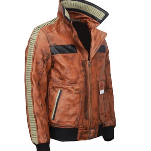 May include: A brown leather jacket with a distressed finish. The jacket features a high collar, black accents, and olive green stripes on the sleeves. It has multiple pockets and a black ribbed hem and cuffs.