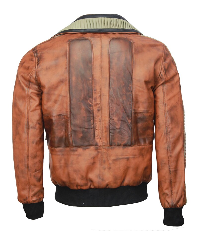 May include: A brown leather jacket with a distressed finish. The jacket features a ribbed collar, two vertical panels on the back, and black ribbed cuffs and hem. The leather has a worn appearance with darker patches.