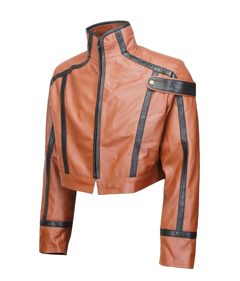 May include: A cropped brown leather jacket with black accents. The jacket features a high collar, a front zipper, and black stripes along the sleeves and shoulders. A black strap with a gold button detail is on the right shoulder.