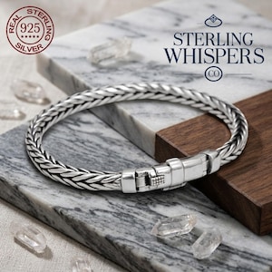 May include: A sterling silver bracelet with a woven design and a secure clasp. The bracelet is displayed on a marble surface with the text "STERLING WHISPERS CO" and "REAL STERLING 925 SILVER" in the image.