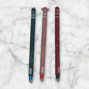 Può includere: Tre penne stilo in verde scuro, rosa e bordeaux. Ogni penna presenta un design unico nella parte superiore e una punta touchscreen. Le penne sono su uno sfondo di marmo bianco. Ideali per dispositivi touchscreen.