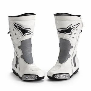 Puede incluir: Un par de botas de moto blancas y grises con detalles en negro. Las botas presentan un logotipo en blanco y negro y un panel gris. Tienen un diseño aerodinámico y están fabricadas con materiales duraderos. Botas de protección.