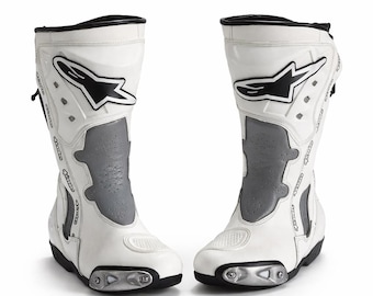 Puede incluir: Un par de botas de moto blancas y grises con detalles en negro. Las botas presentan un logotipo en blanco y negro y un panel gris. Tienen un diseño aerodinámico y están fabricadas con materiales duraderos. Botas de protección.
