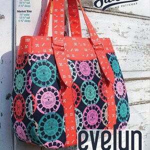 May include: A red and patterned tote bag with a black background and colorful circular designs. The bag has red straps and a red top with white polka dots. The text "Evelyn Handbag & Market Tote" is visible.
