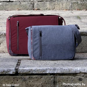 Peut inclure: Deux sacs messagers, l'un rouge et l'autre bleu, sont présentés sur un escalier en pierre. Les sacs ont une fermeture à rabat et une poche zippée sur le devant. Le texte "The Morgan Messenger Bag" est en haut de l'image. Le texte "You may sell bags made from this pattern" est sous le titre. Le texte "In two sizes! Finished sizes approx: Width x Height x Depth Small - 11 3/2" x 9" x 3 1/2" (29cm x 23cm x 9cm) Large - 14 1/2" x 12" x 4" (37cm x 30.5cm x 10cm)" est sous les sacs. Le texte "Photography by Lynne Baldwin SEWING PATTERNS by "Mrs h." est en bas de l'image.