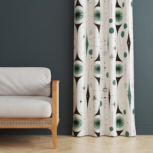 May include: White curtain with a mid-century modern design featuring black, teal, and grey geometric shapes. The pattern includes stylized eye-like forms, diamonds, dots, and starbursts. The curtain is hanging in front of a dark teal wall.