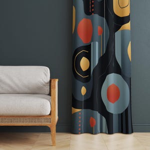 May include: Abstract patterned curtain with orange, yellow, and black shapes on a teal background. The curtain is next to a light grey sofa with a wooden frame, creating a modern aesthetic. The curtain is likely 200cm in length.