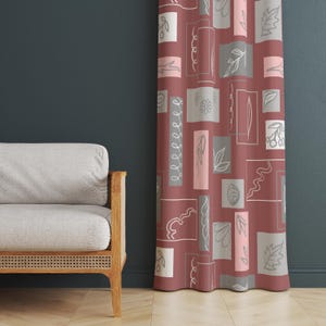 Puede incluir: Una cortina granate con un patrón repetitivo de formas rectangulares y cuadradas. Las formas contienen varios diseños florales y abstractos en blanco, gris y rosa. La cortina cuelga frente a una pared azul oscuro.