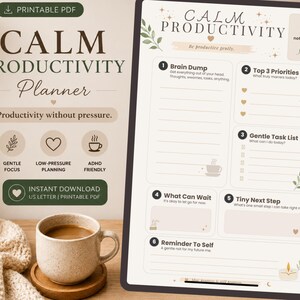 Op de afbeelding: Een digitale planner met de tekst "CALM PRODUCTIVITY Planner" en de zin "Productiviteit zonder druk". De planner bevat secties voor taken en prioriteiten. Een kopje koffie en een kaars zijn ook zichtbaar. Afmetingen in cm.