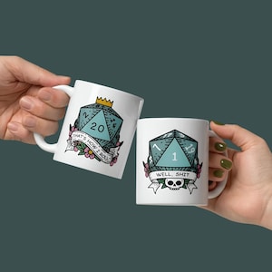 以下が含まれることがあります： サイコロのデザインが施された2つの白いセラミックマグ。1つのマグには、数字20のターコイズ色のサイコロ、「that's how I roll」の文字、花のアクセントが描かれています。もう1つのマグには、数字1のターコイズ色のサイコロと「well, shit」の文字が描かれています。