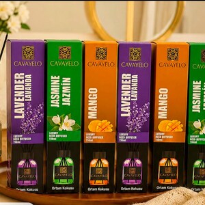May include: Six rectangular boxes of Cavayelo luxury reed diffusers in 110ml sizes, arranged in a row. The boxes feature purple, green, and orange colors with lavender, jasmine, and mango illustrations, along with the brand name and scent labels.