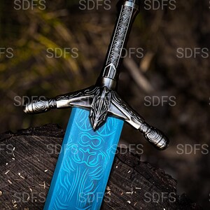 May include: A detailed close-up of a fantasy sword with a bright blue blade and ornate silver hilt. The blade features intricate etched designs. The sword rests on a dark, textured wooden surface.
