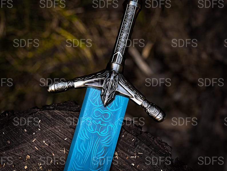 May include: A detailed close-up of a fantasy sword with a bright blue blade and ornate silver hilt. The blade features intricate etched designs. The sword rests on a dark, textured wooden surface.