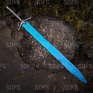 May include: A blue sword with a detailed blade design rests on a dark wooden surface. The sword has a silver-colored hilt and crossguard. The background features dark earth and foliage, creating a contrast with the bright blue blade.