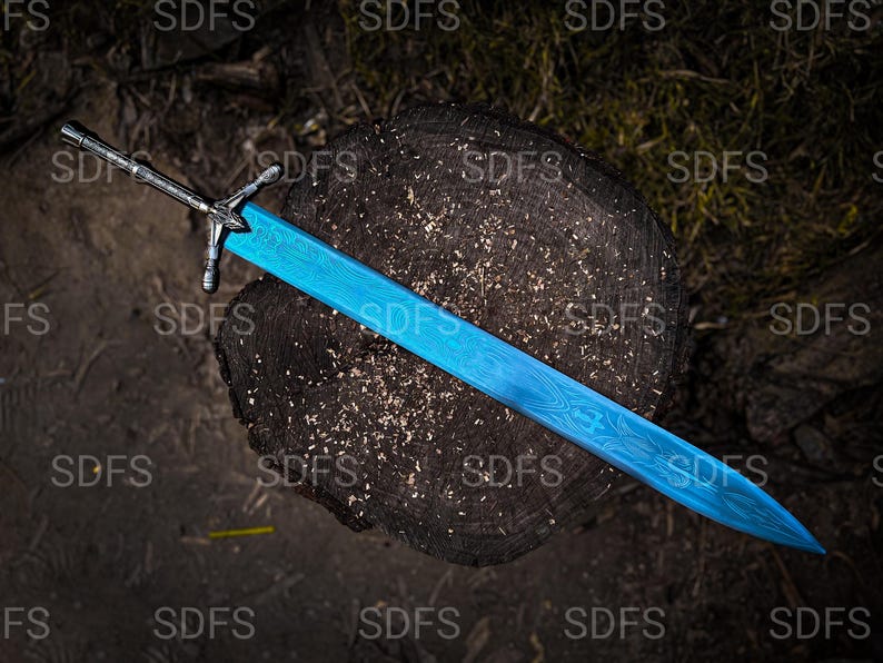 May include: A detailed overhead shot of a sword with a bright blue blade and a silver handle. The blade has a patterned design. The sword rests on a dark, textured wooden surface.