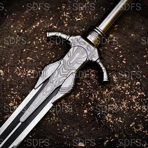 May include: A detailed, silver-colored sword with intricate designs on the hilt and blade. The sword features a black stripe down the center of the blade. The weapon rests on a dark, textured wooden surface.